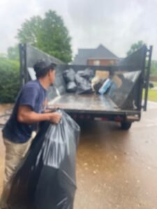 Man loading trash bags into trailer