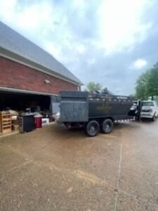 Dump trailer parked outside brick garage