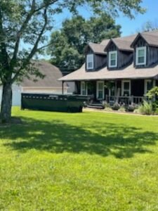 Large dumpster outside charming dormer house
